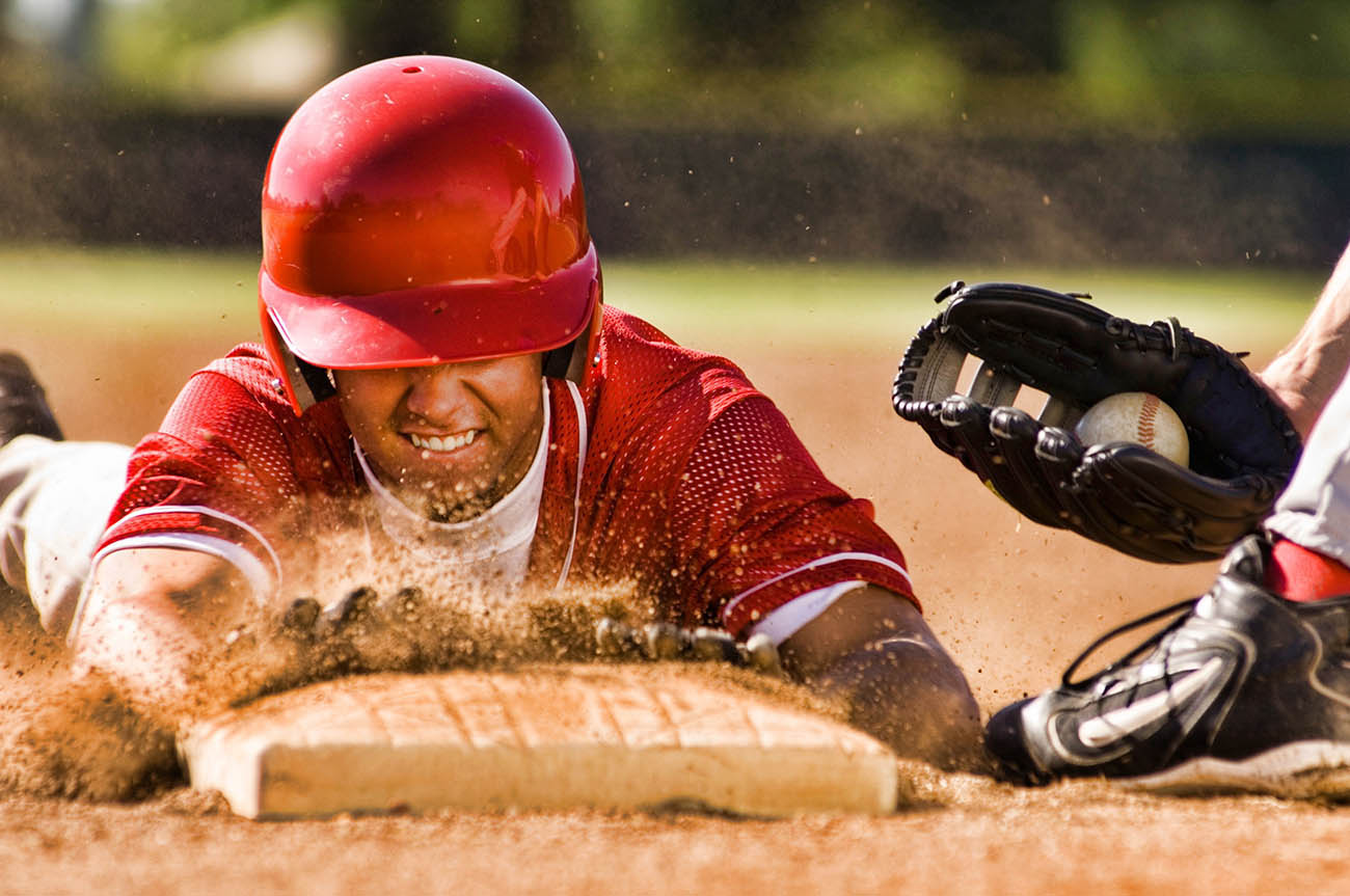 Portrait of man stealing base in baseball